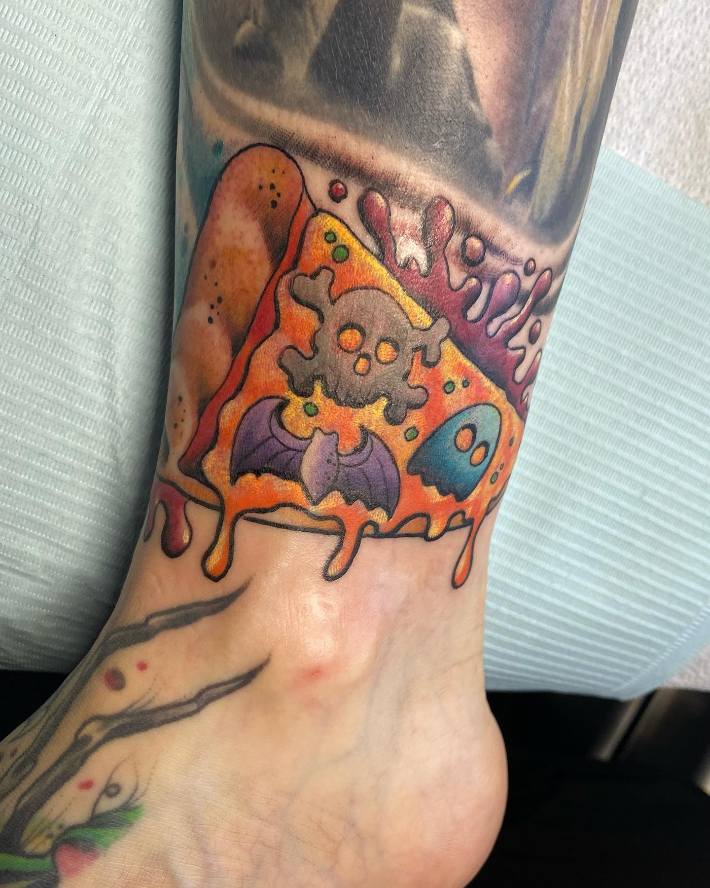 Tatuaje brillante y colorido en el tobillo.