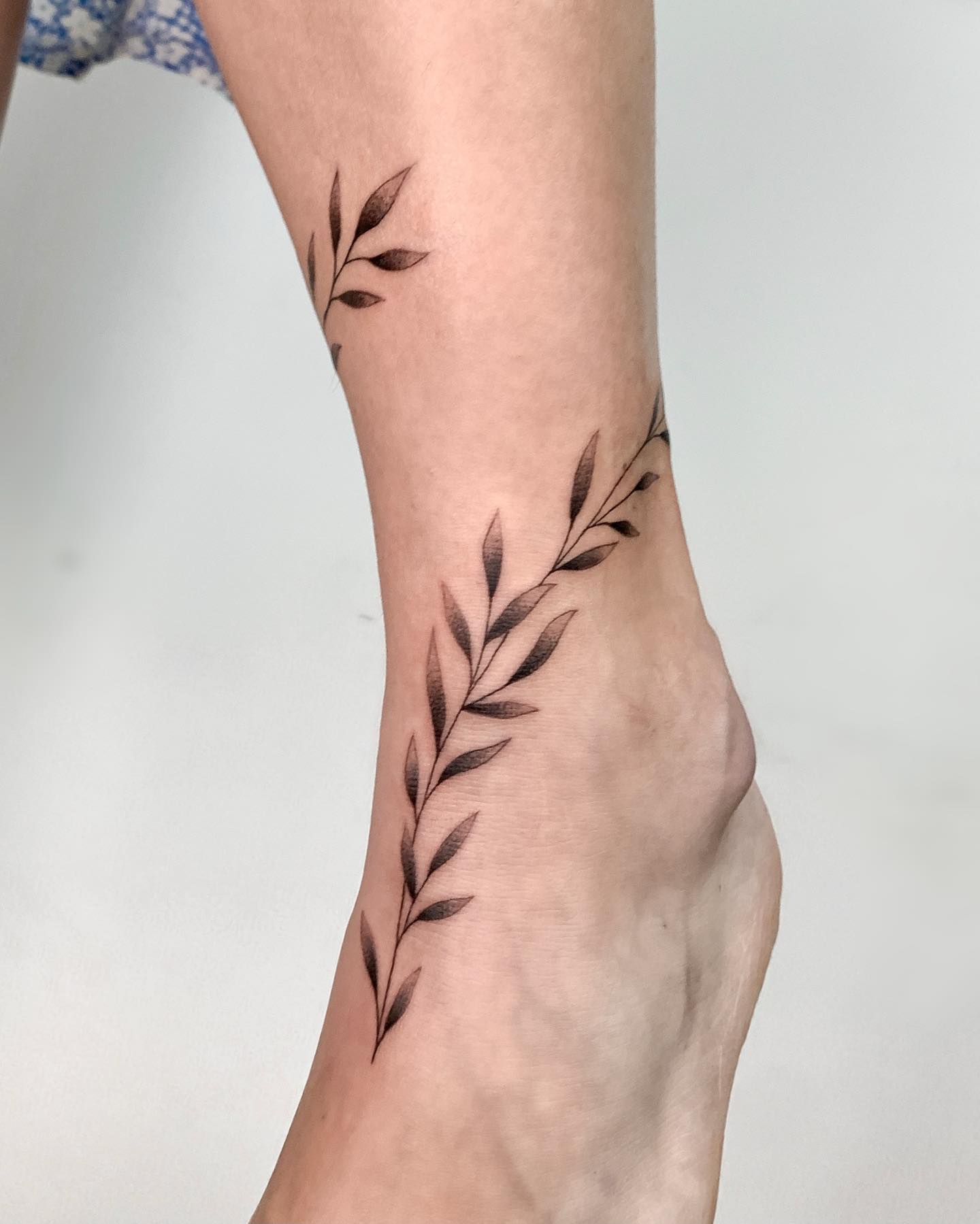 Tatuaje de hoja en el tobillo.