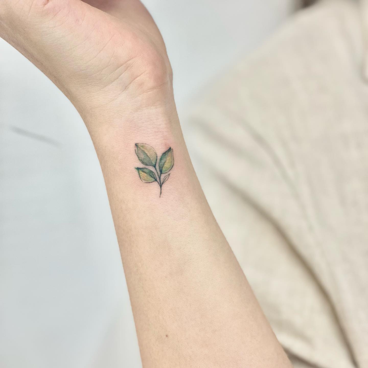 Tatuaje de muñeca floral verde