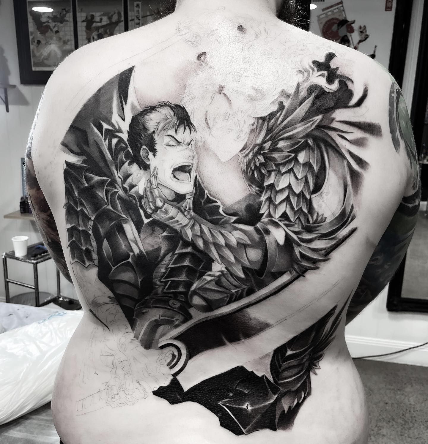 Tatuaje de Naruto vs Guts en la espalda