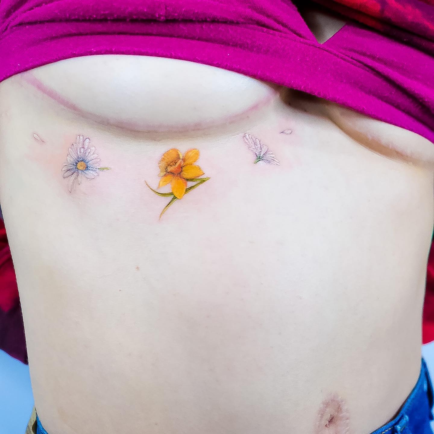 Tatuaje de narciso debajo del pecho
