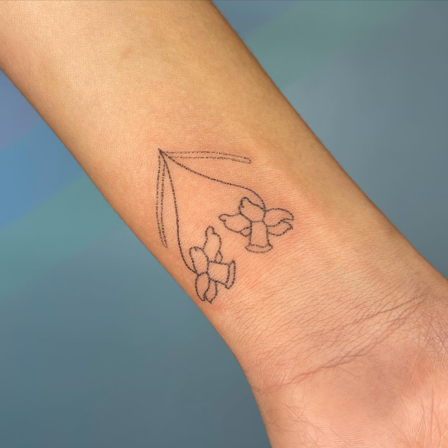 Tatuaje de Narciso en una muñeca pequeña.