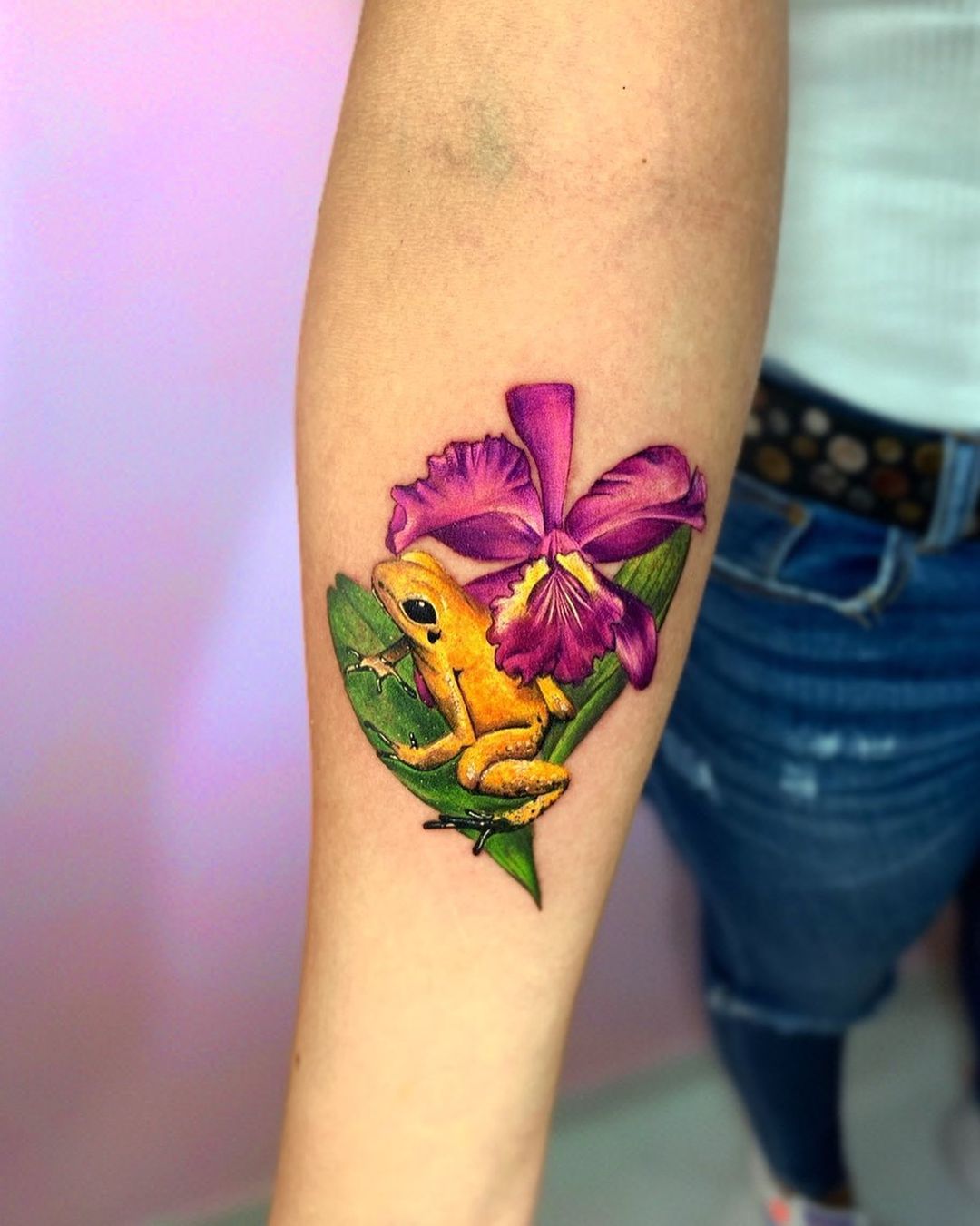 Tatuaje brillante de orquÃdea con una rana