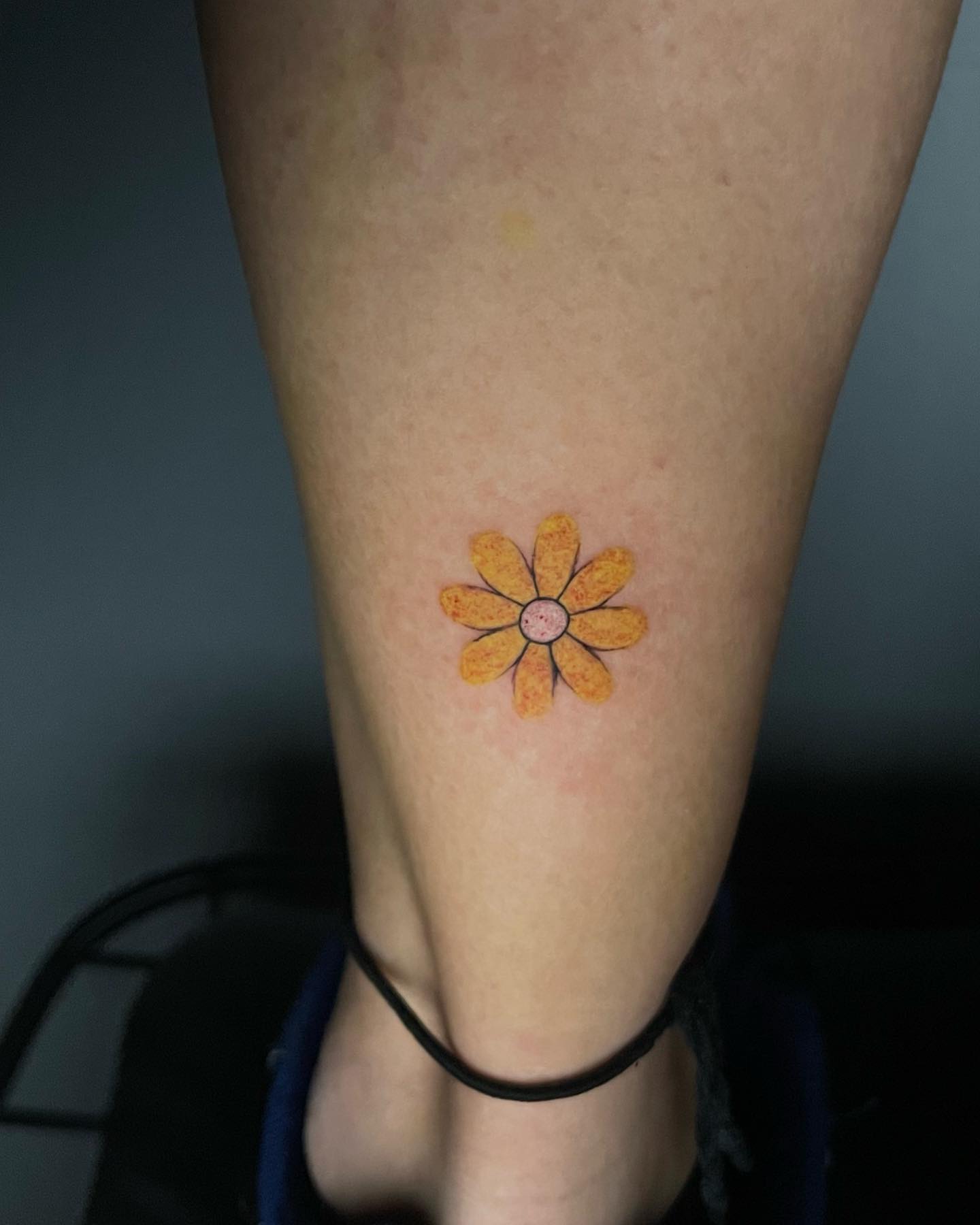 Tatuaje de margarita amarilla linda.