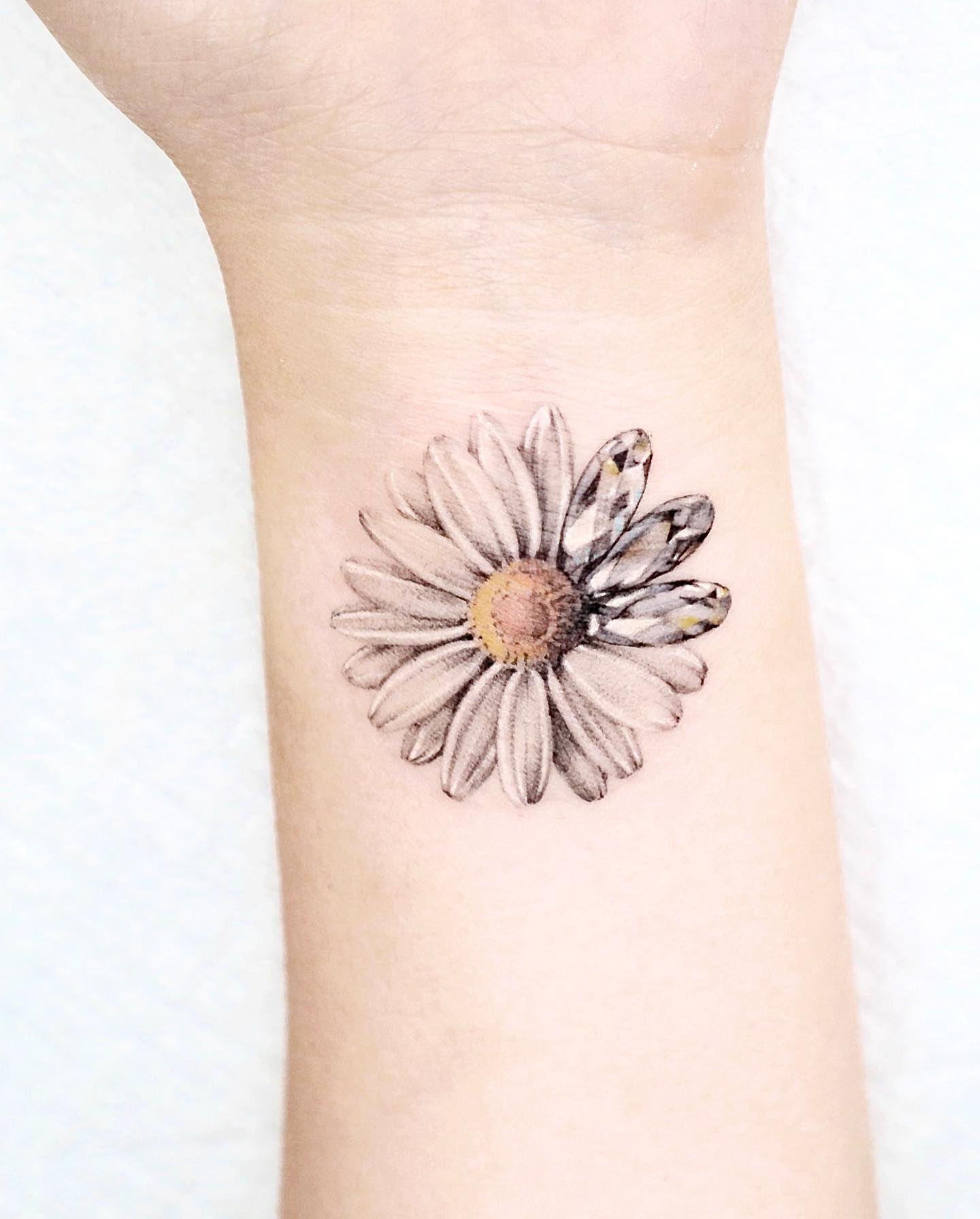 Tatuaje de margarita fresco en el antebrazo.