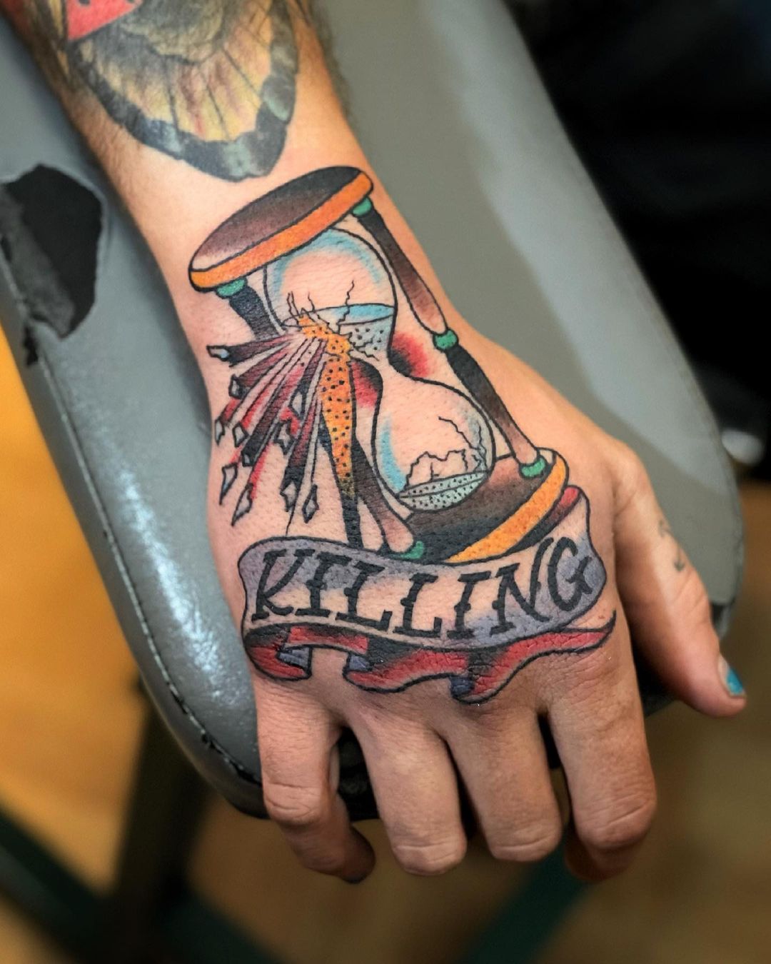 Tatuaje de reloj de arena en la mano
