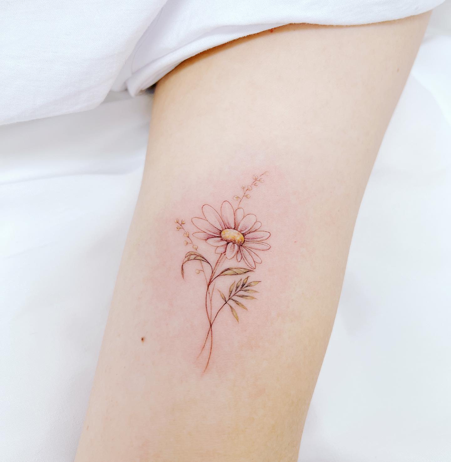 Tatuaje pequeño y sencillo de margarita.