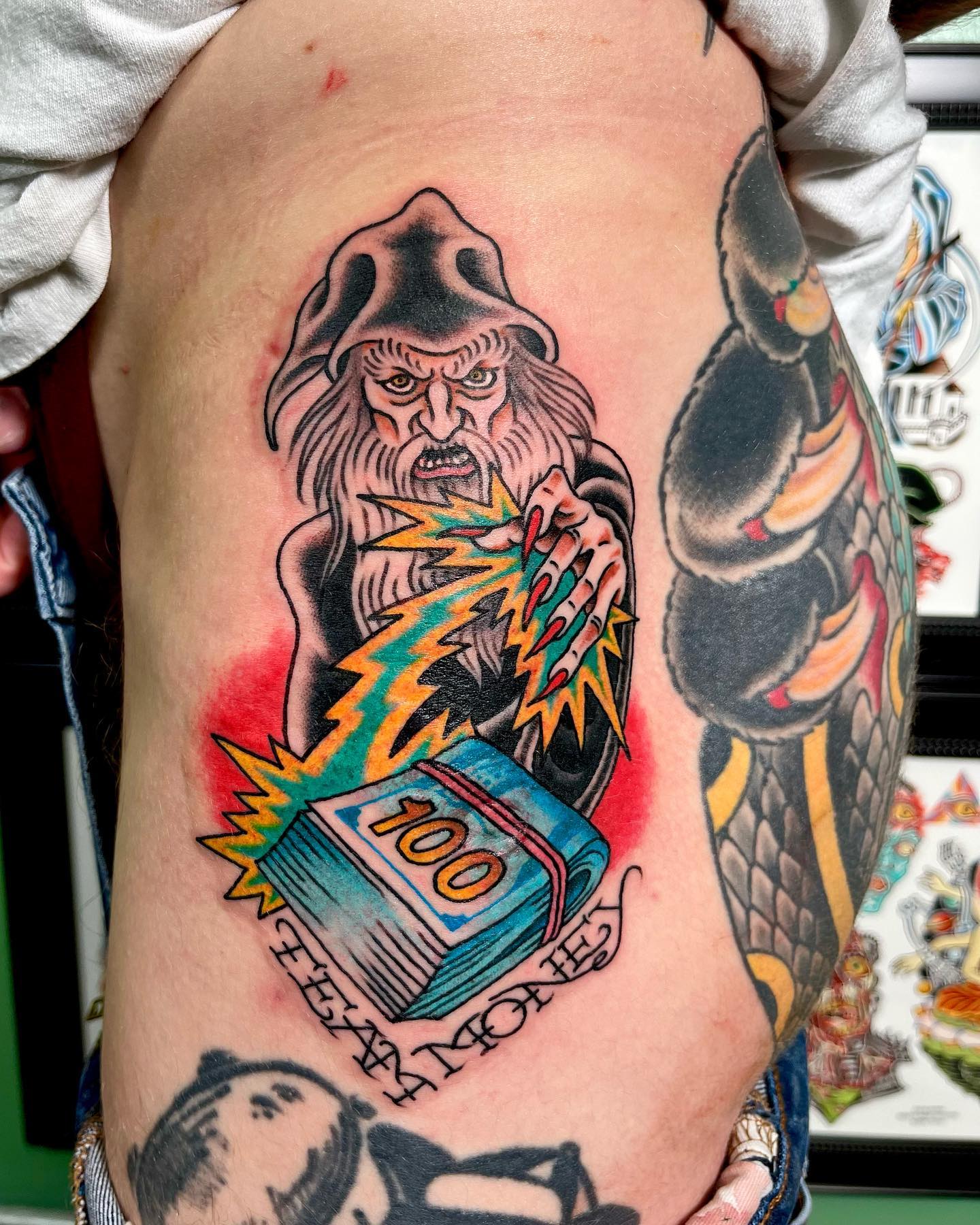 Tatuaje de dinero en el muslo colorido.