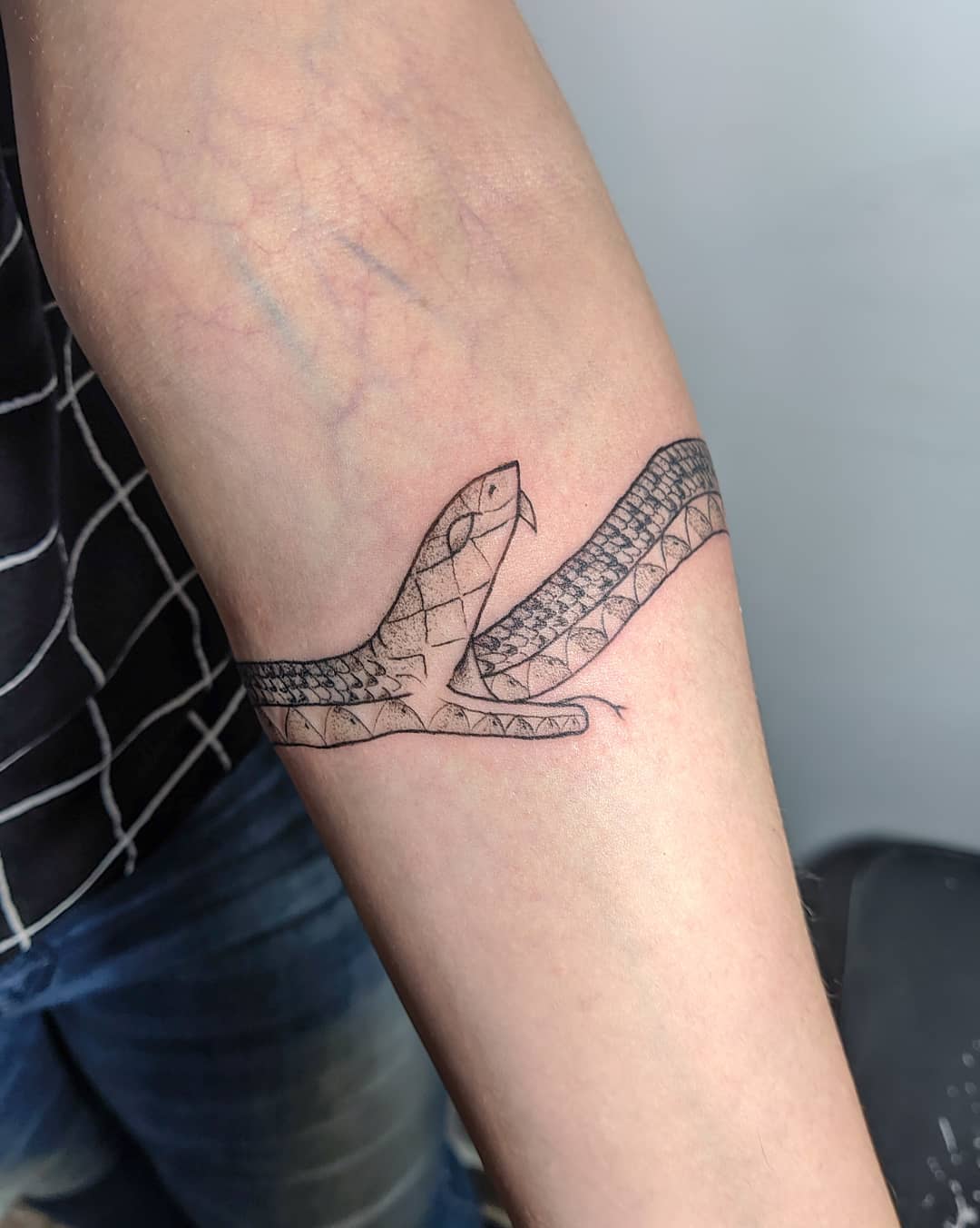 Tatuaje de Ouroboros con contorno negro.