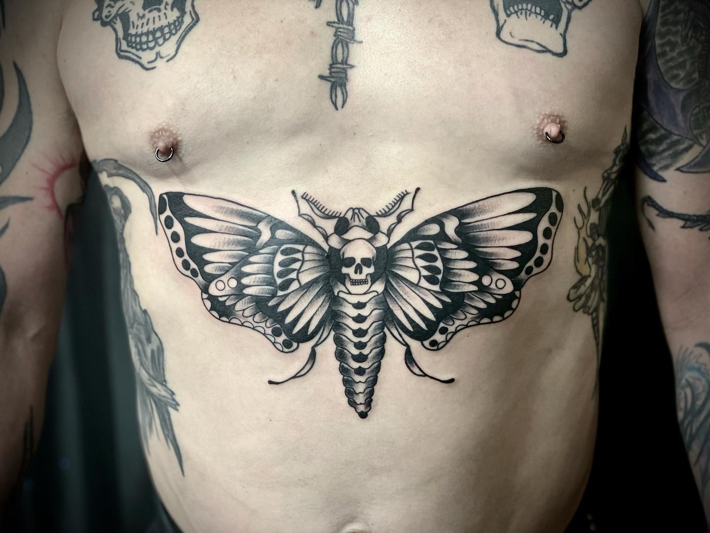 Tatuaje de polilla negra en el pecho para hombres.