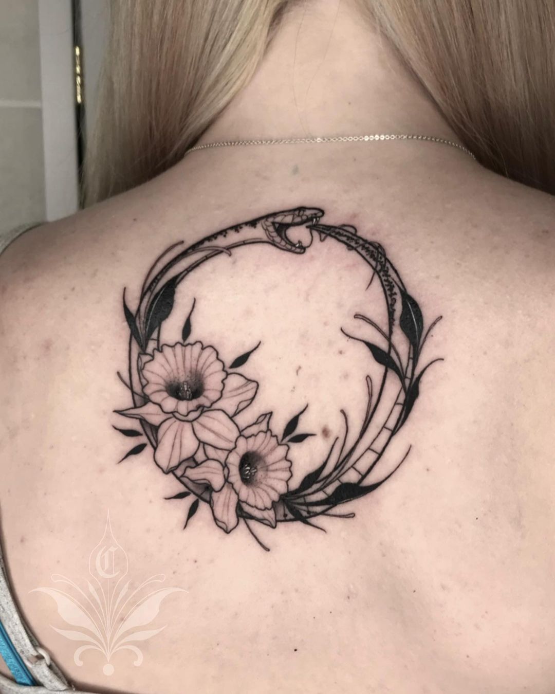 Tatuaje grande de Ouroboros en la espalda.