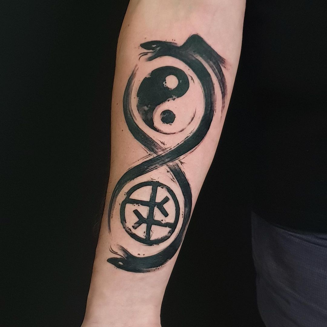 Tinta negra, diseño de ouroboros tatuado en el antebrazo.