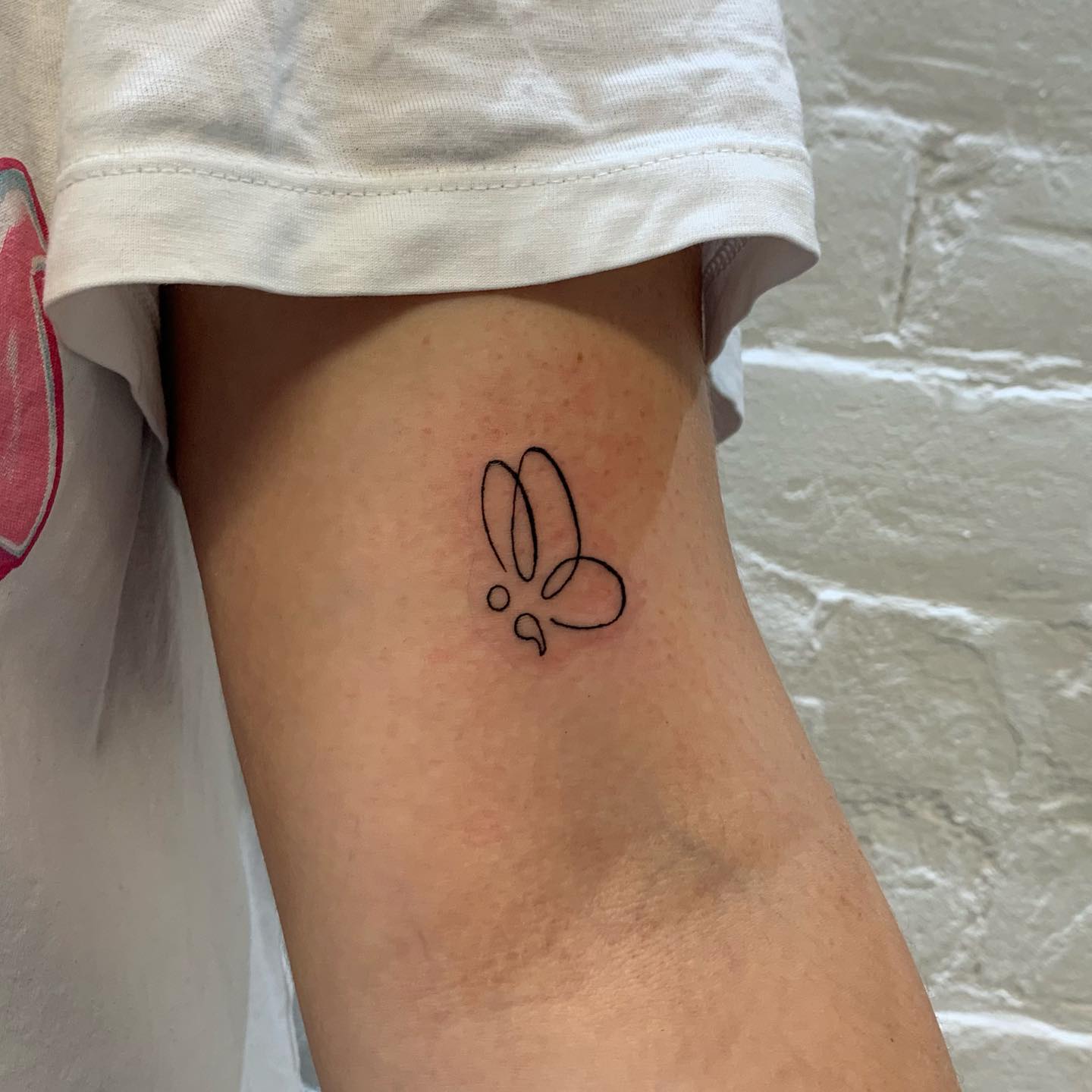 Pequeño diseño de tatuaje negro con punto y coma.