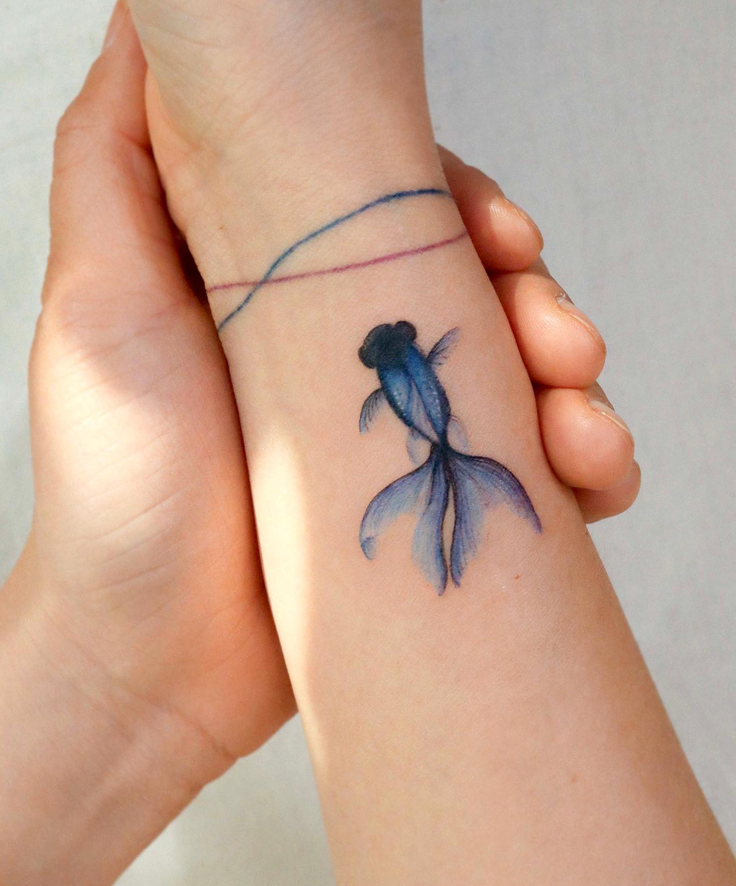 Pequeño tatuaje de encubrimiento de pez.