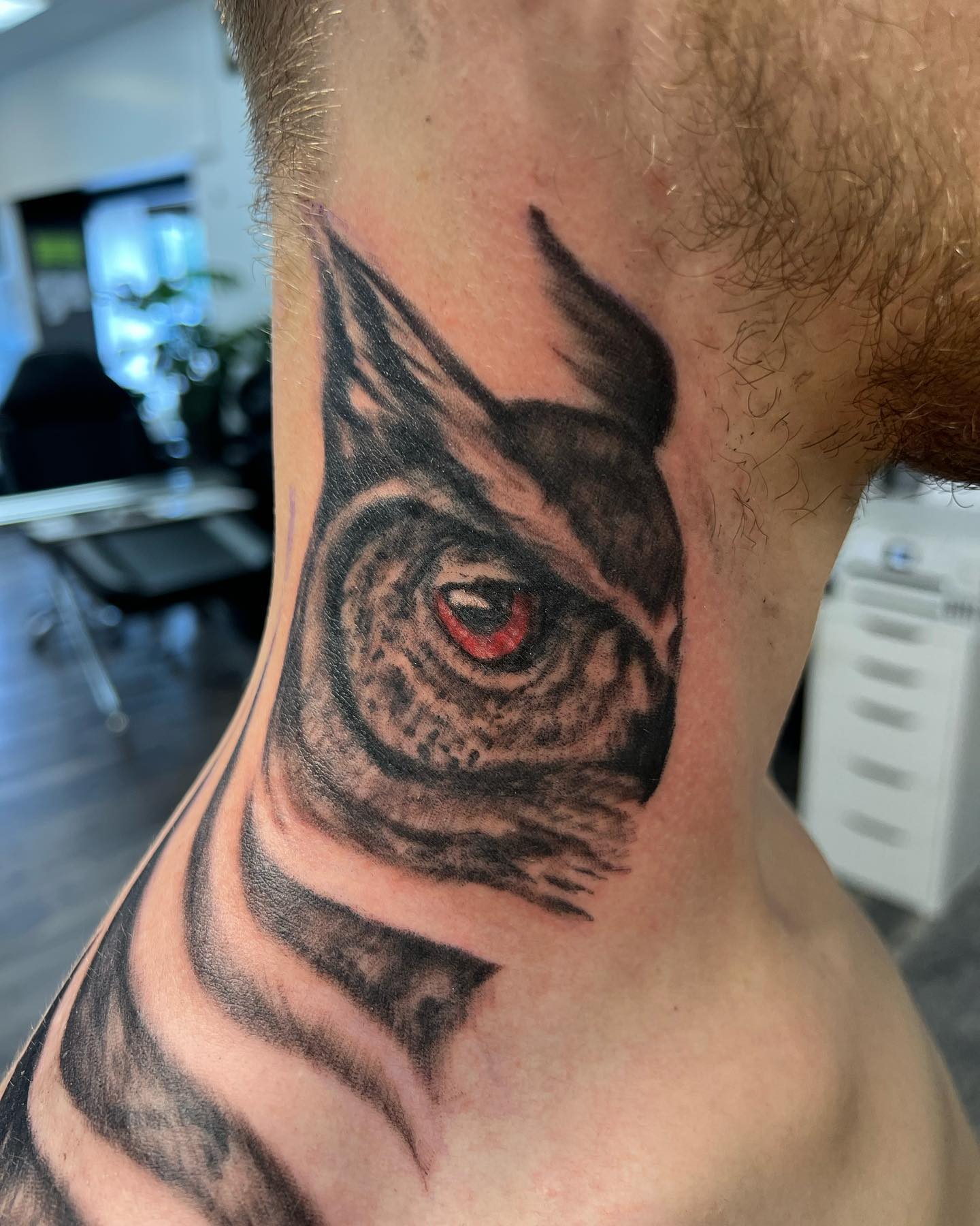 Tatuaje de búho en el cuello.