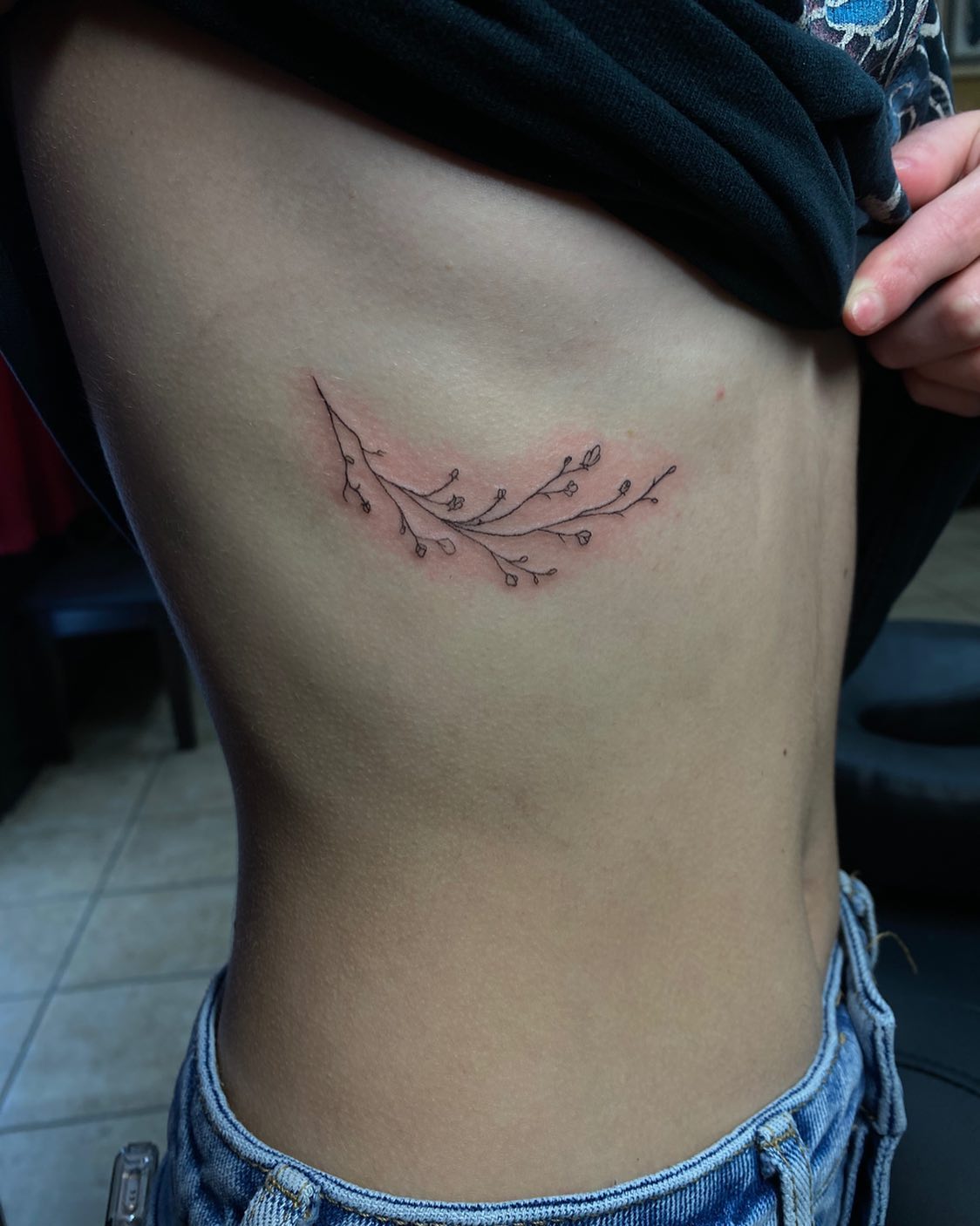 Tatuaje de costilla lateral con follaje.