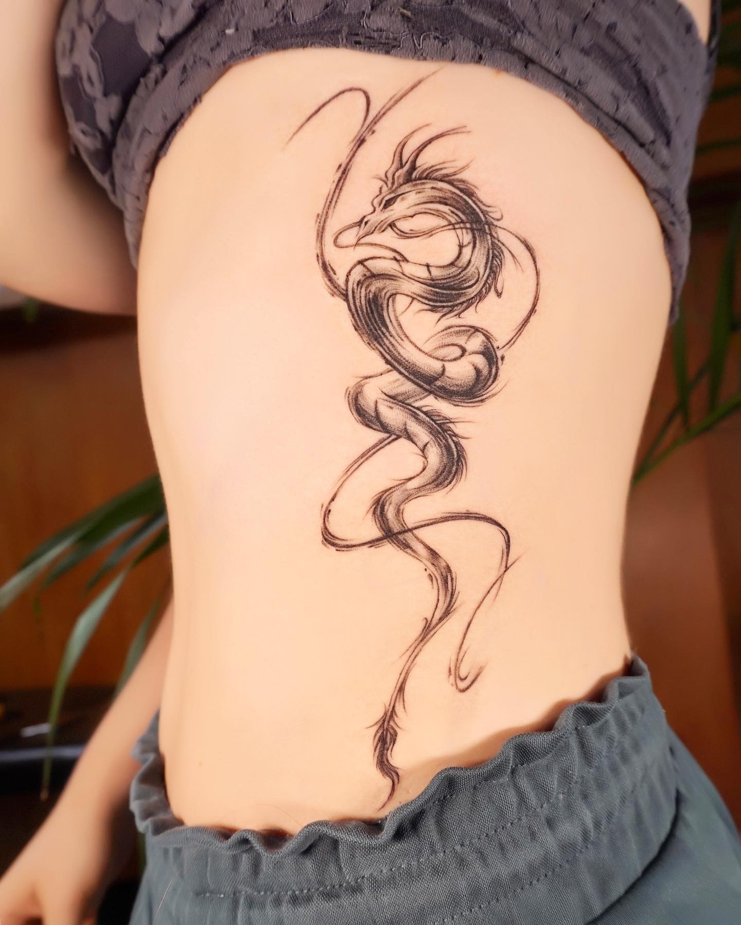 Tatuaje de Dragón Negro en las Costillas Laterales