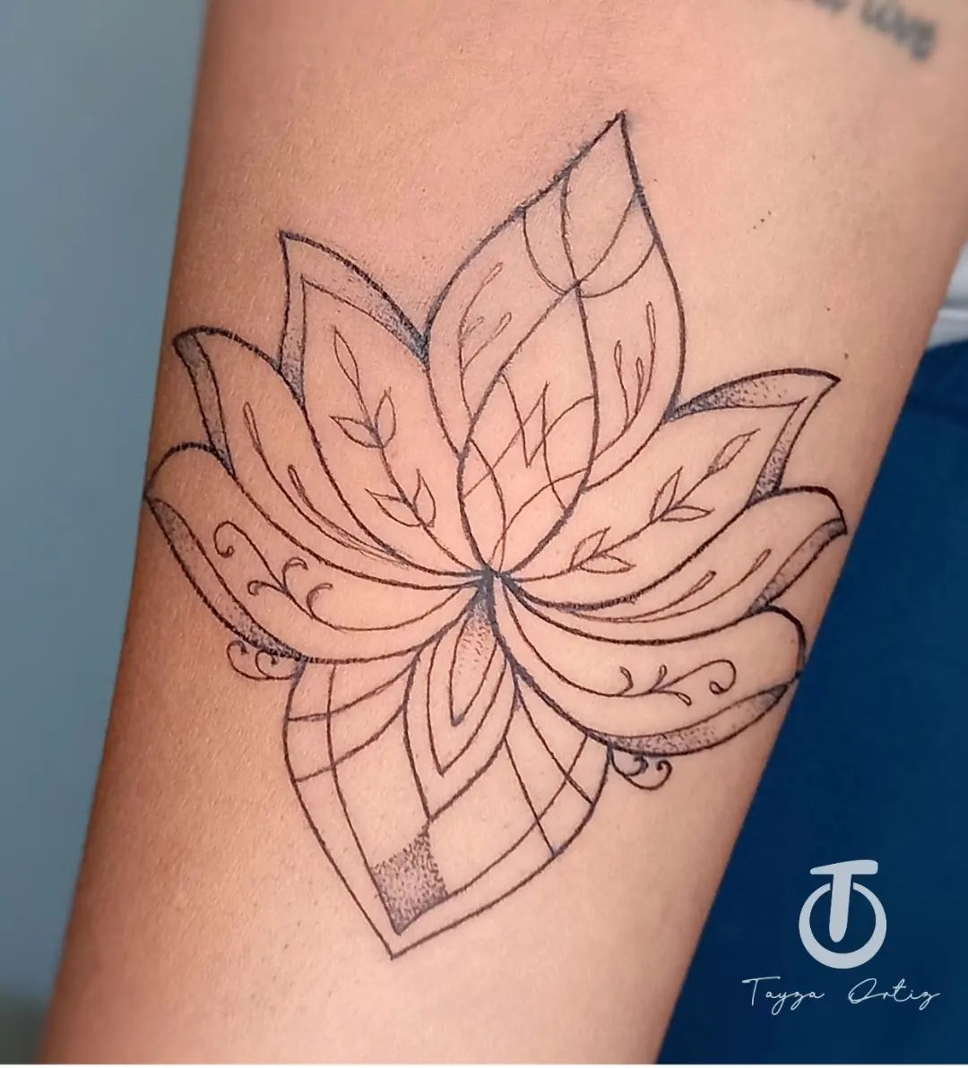 Tatuaje de loto delicado tinta negra.