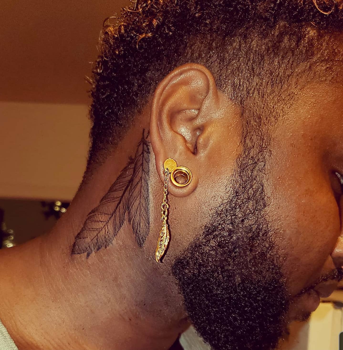 Tatuaje de pluma en el cuello
