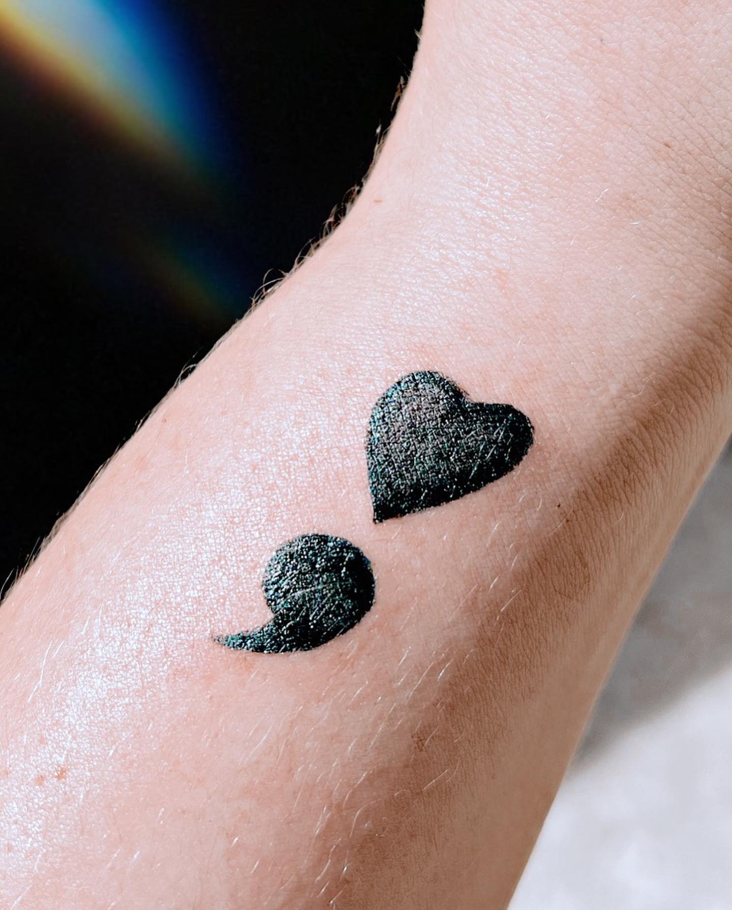 Tatuaje de punto y coma en la muñeca