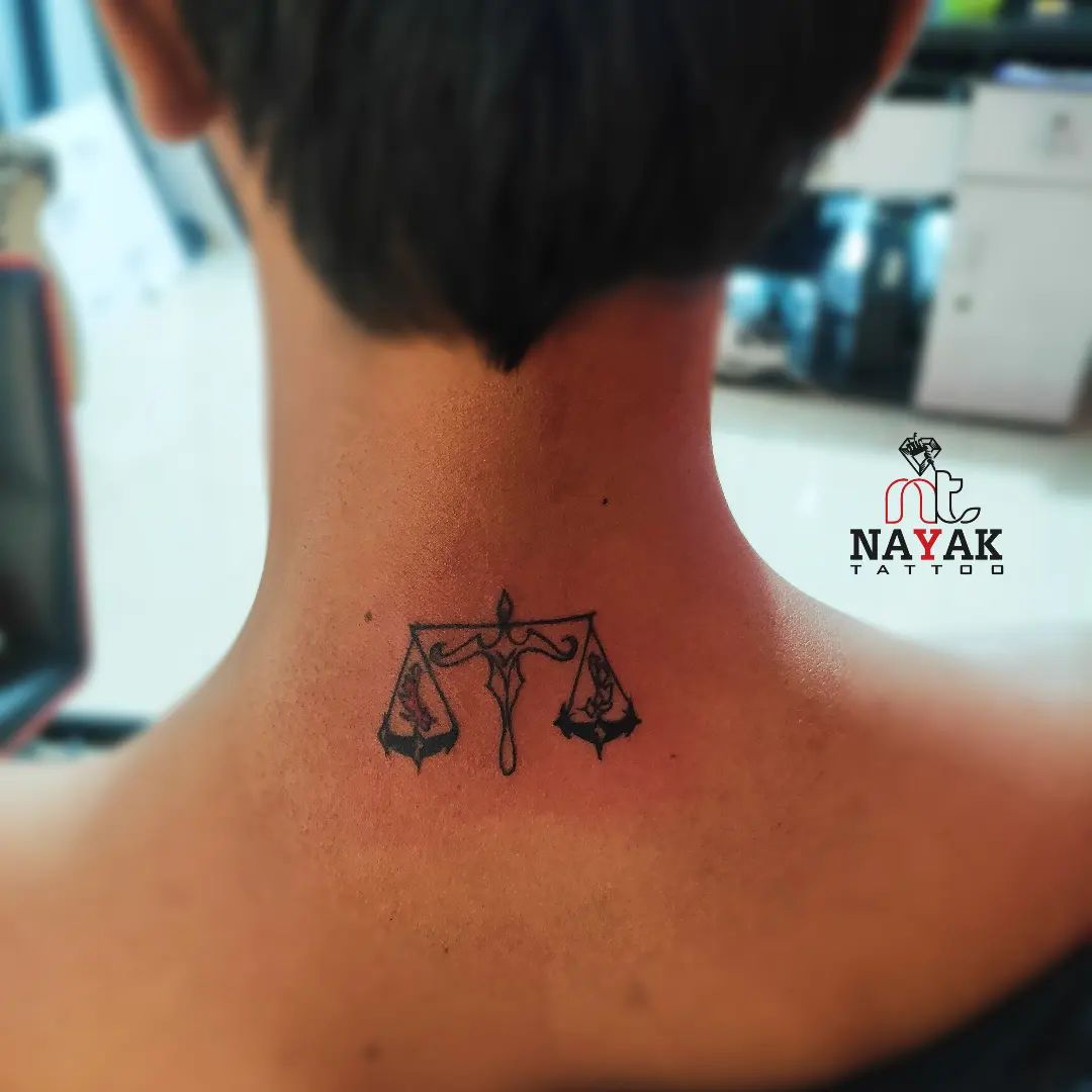 Un par de básculas tatuadas en el cuello.