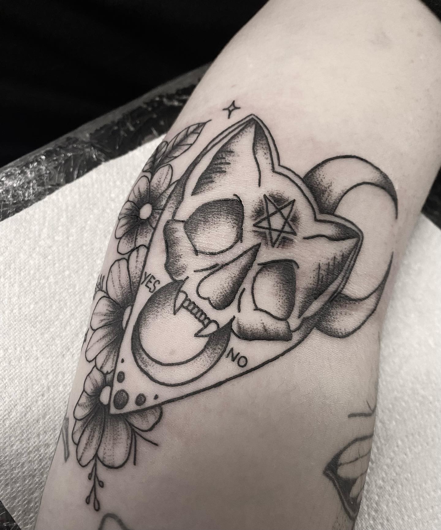 Tatuaje bruja con calavera en tinta negra.