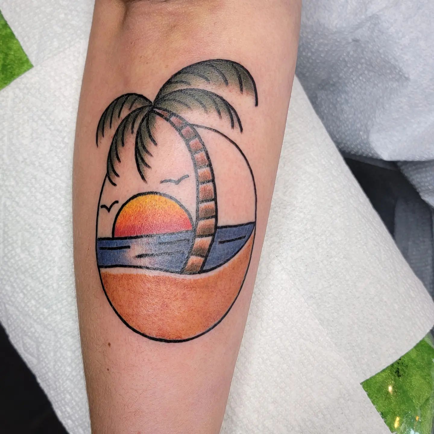 Tatuaje clásico de palmera y atardecer