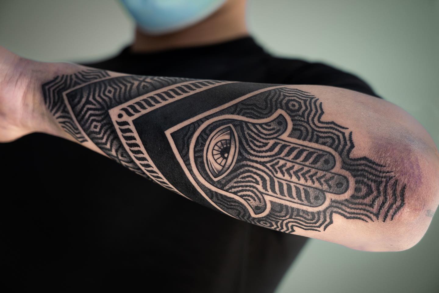Tatuaje de Hamsa en técnica Blackwork en el antebrazo.