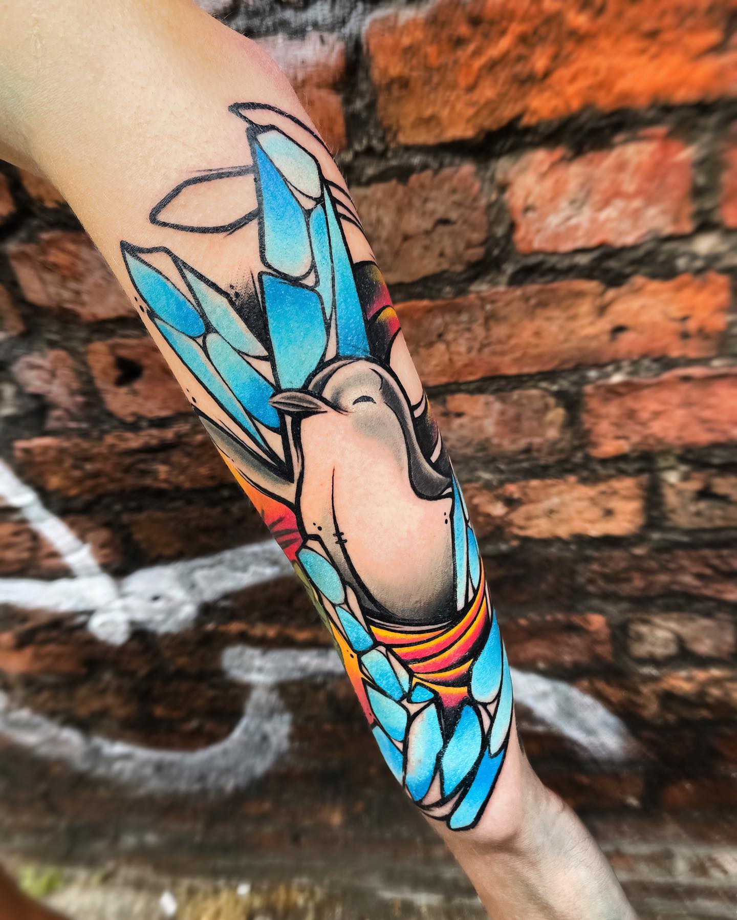 Tatuaje de pingüino de colores brillantes.