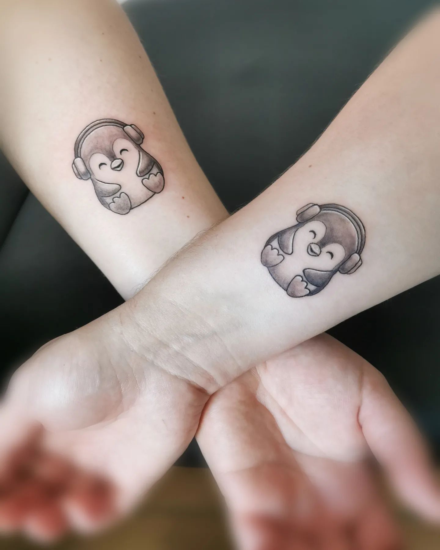 Tatuaje de pingüino en la muñeca.