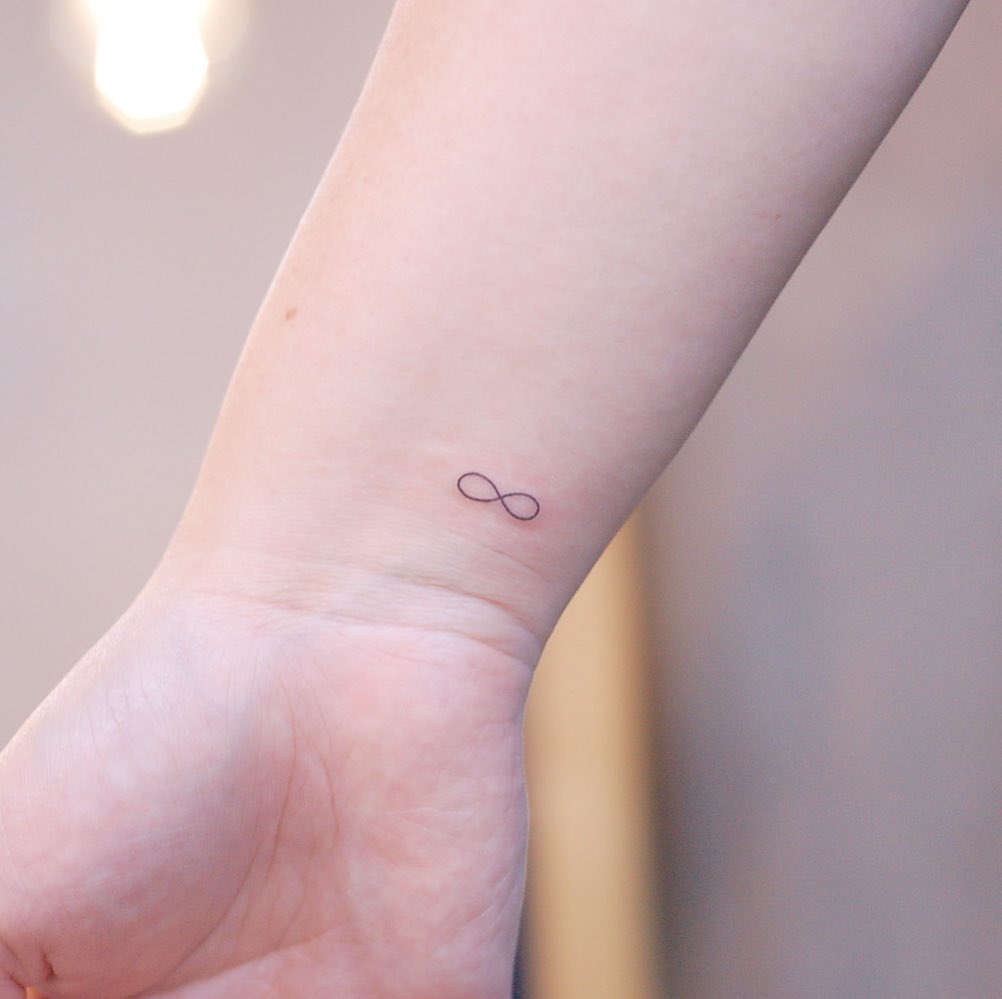 Pequeño tatuaje de infinito en la muñeca