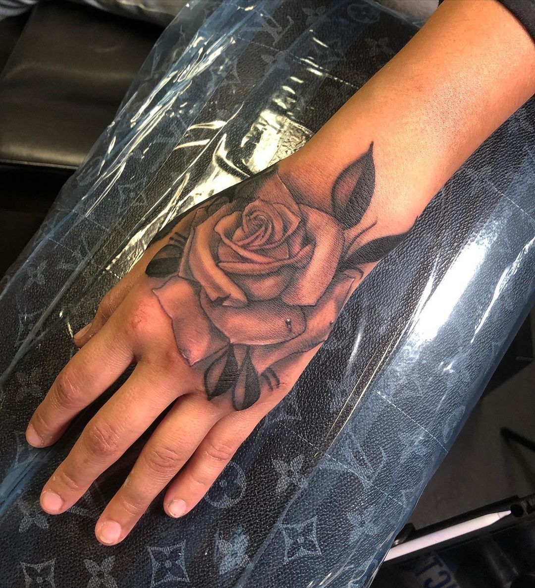 Tatuaje de rosa en la mano para hombres.