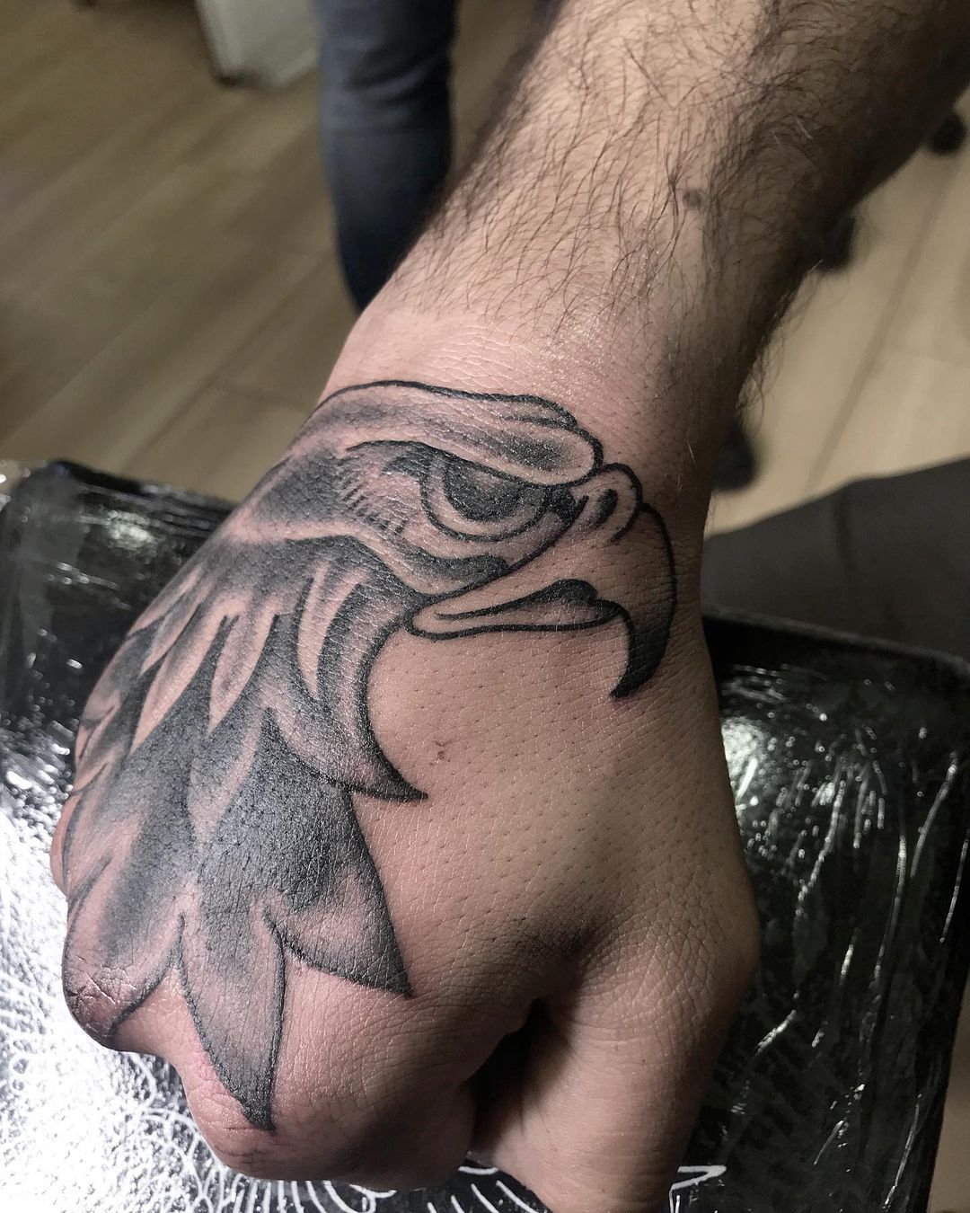 Tatuaje en la Mano de un Halcón Negro para Hombres.