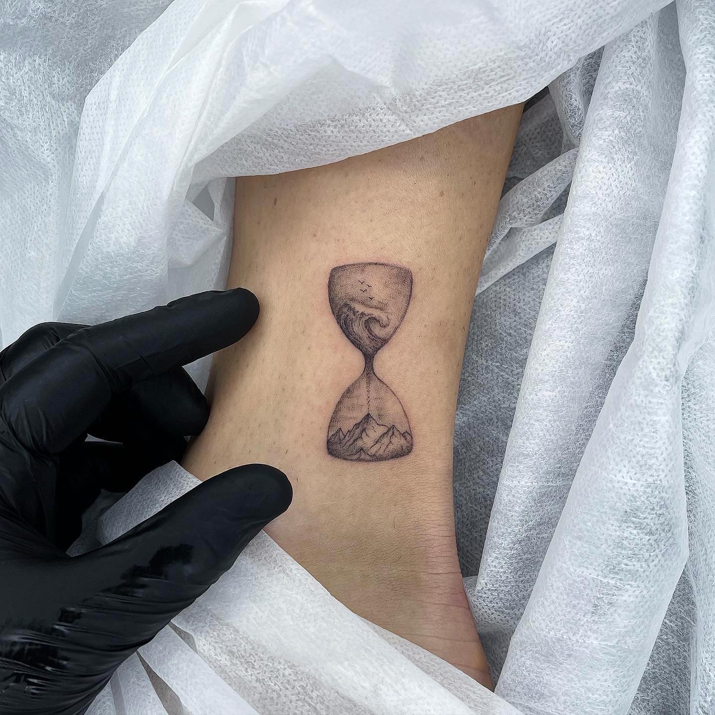 Pequeño tatuaje de reloj de arena para hombres.