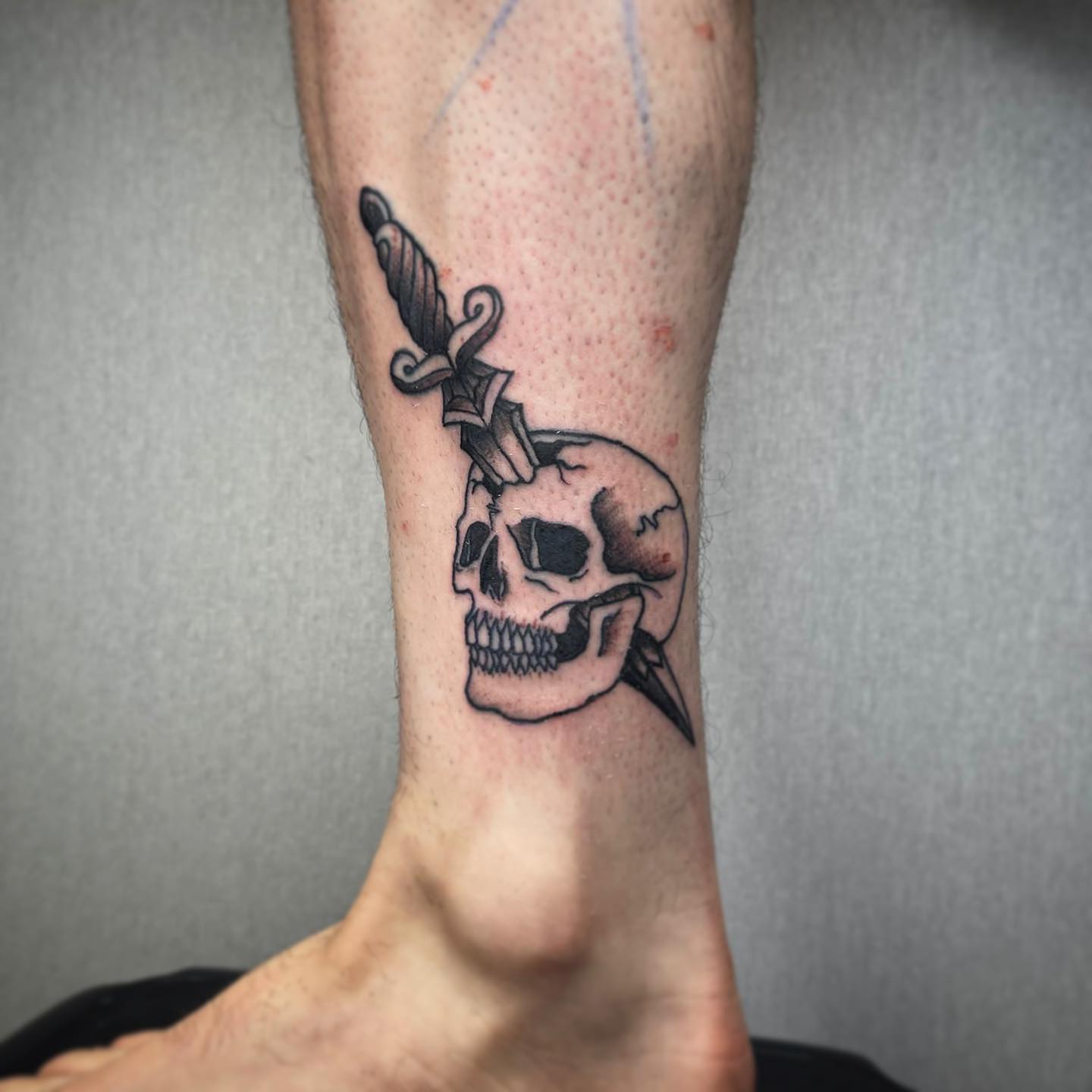 Tatuaje de cráneo apuñalado para hombres.