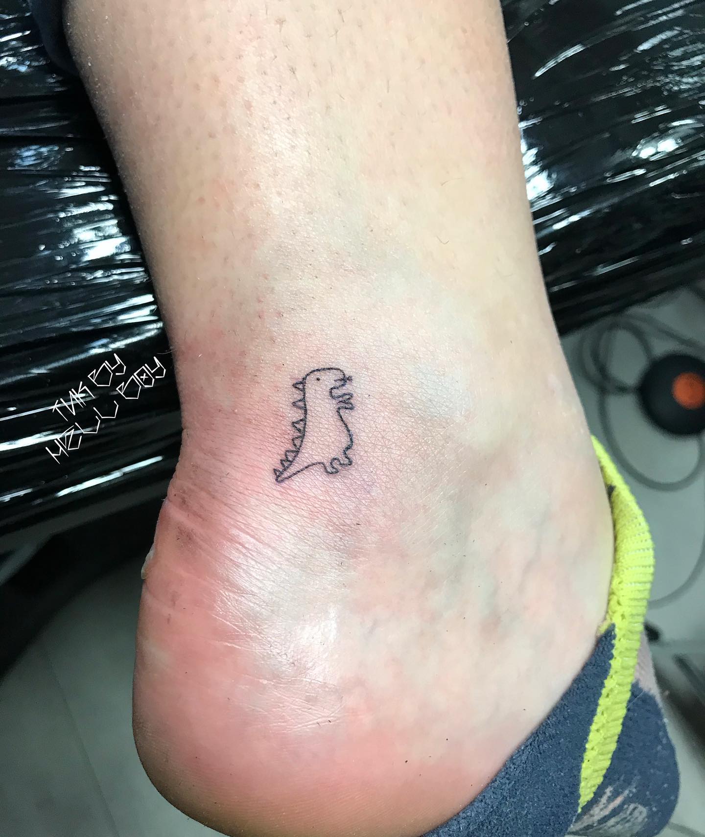 Tatuaje de dinosaurio minimalista para hombres.