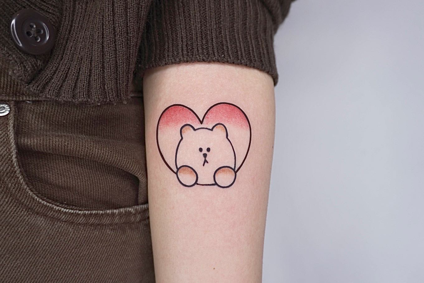 Tatuaje divertido de dibujos animados en el brazo.