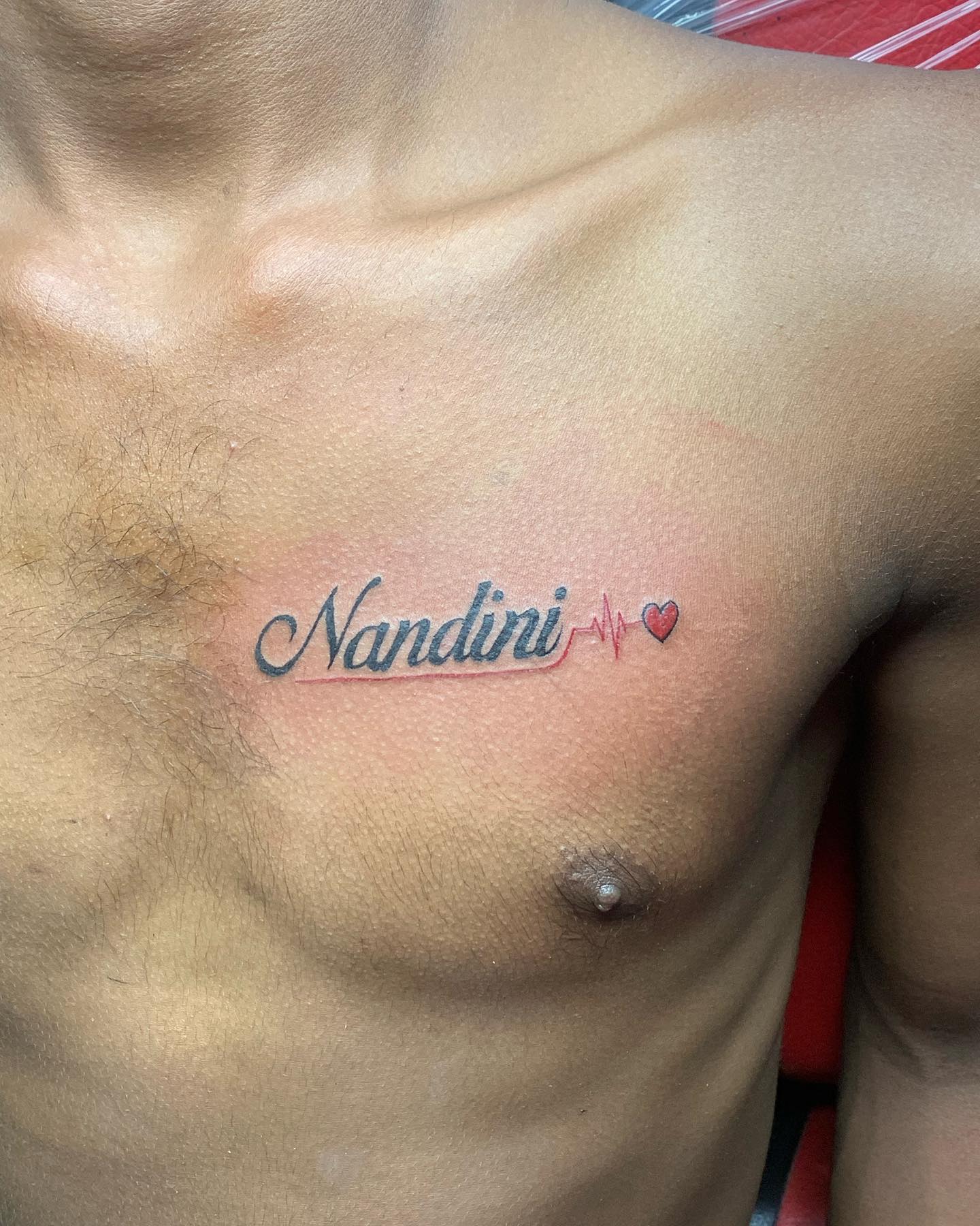 Tatuaje pequeño en el pecho con nombre.