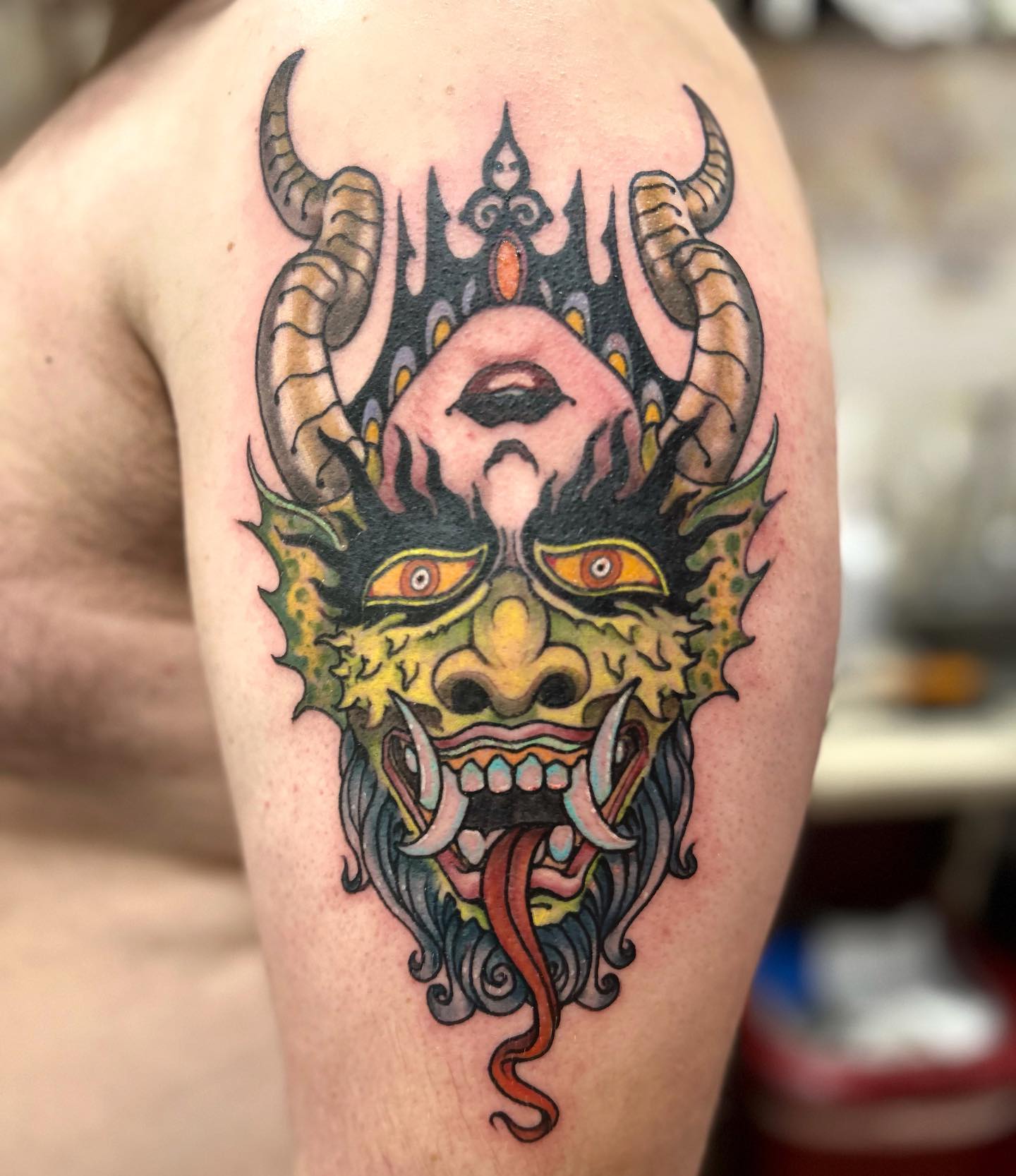 Aterrador tatuaje de demonio en el bíceps
