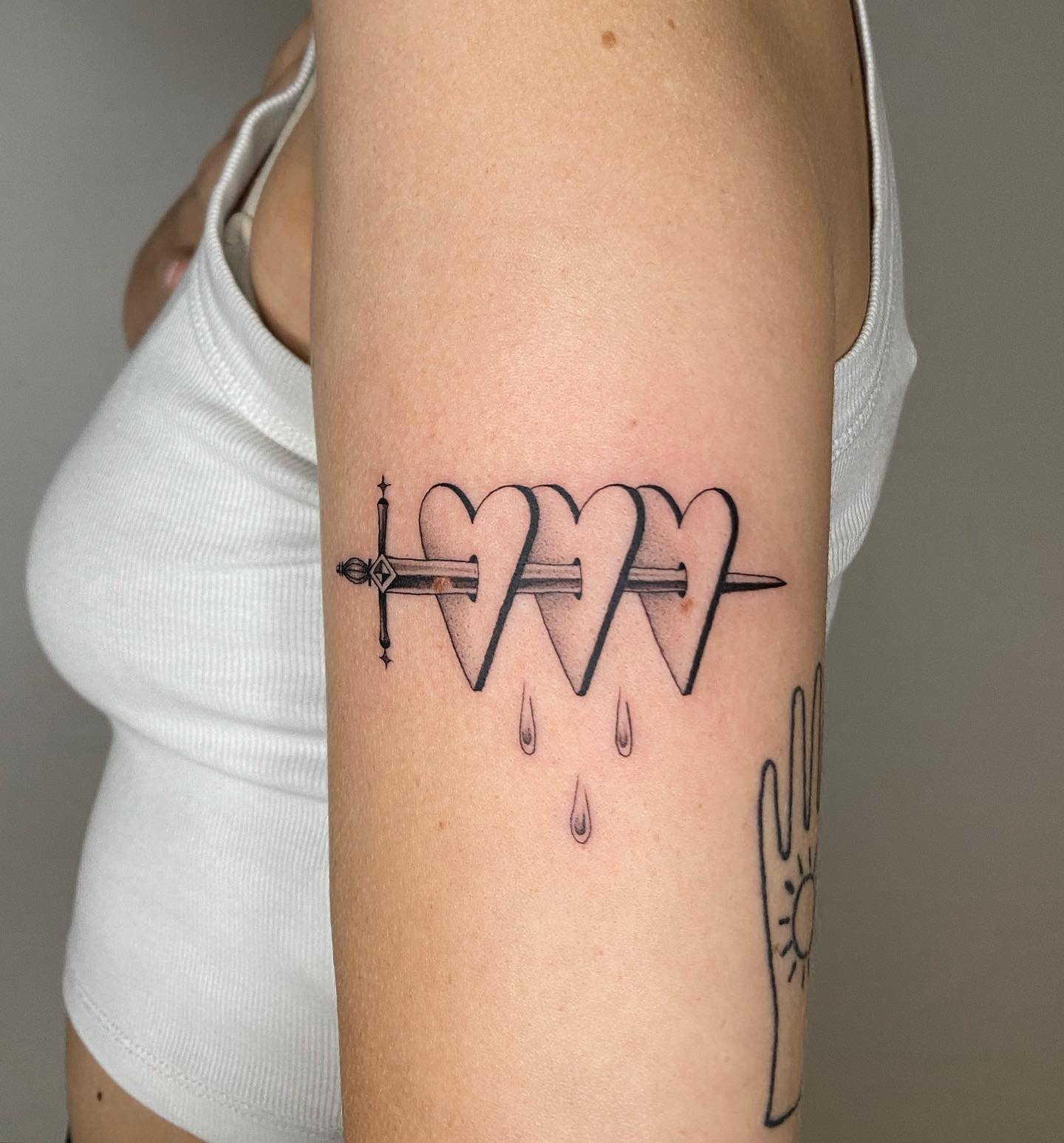 Tatuaje de daga y estampado de rosa.