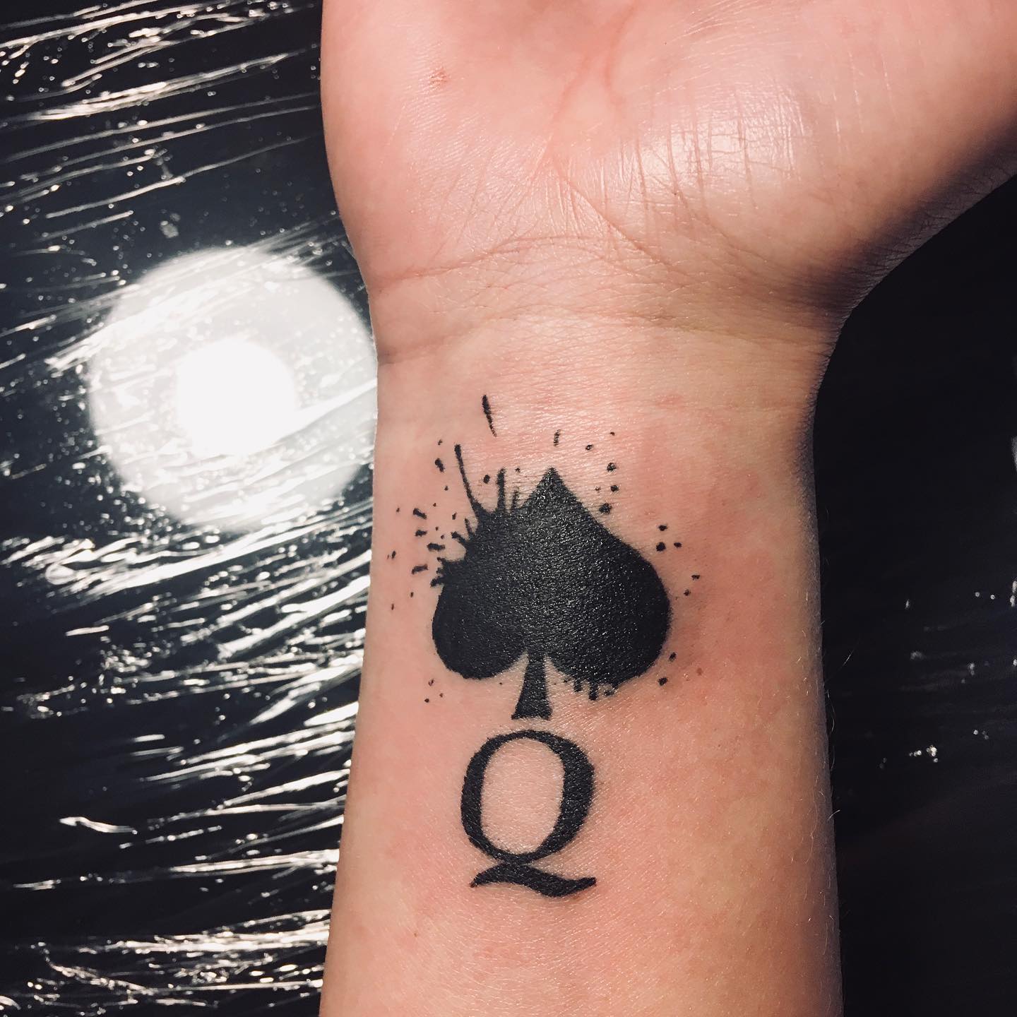 Tatuaje de Reina de Espadas en la muñeca.