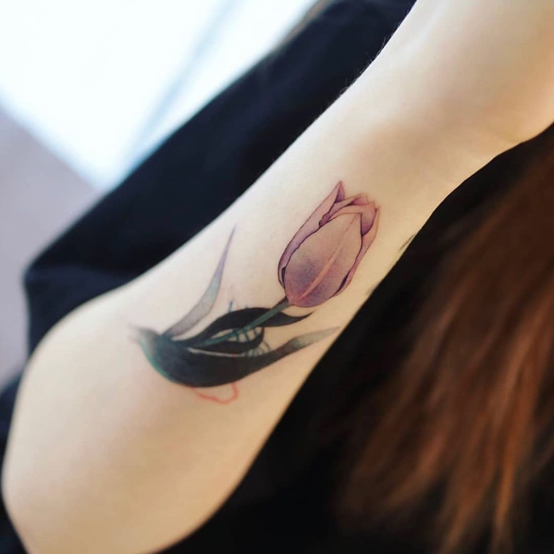 Pequeño tatuaje de tulipán en antebrazo.