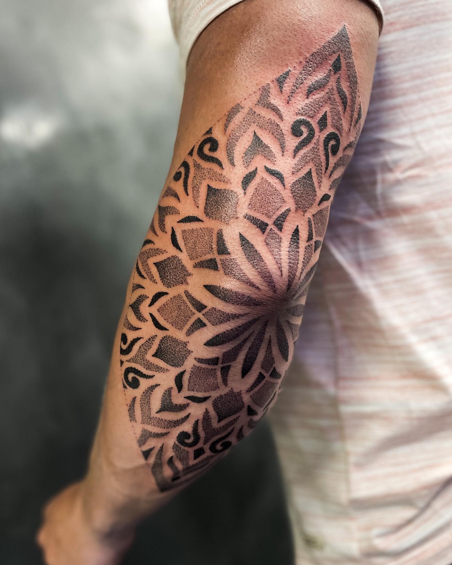 Tatuaje de codo con sombreado negro.
