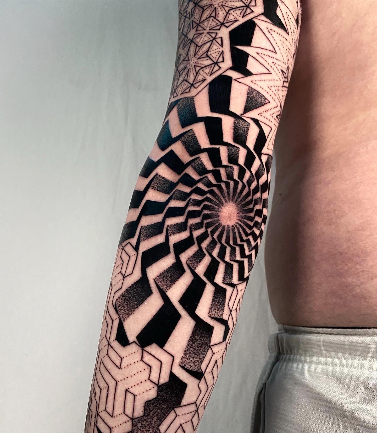 Tatuaje genial en codo con tinta negra.