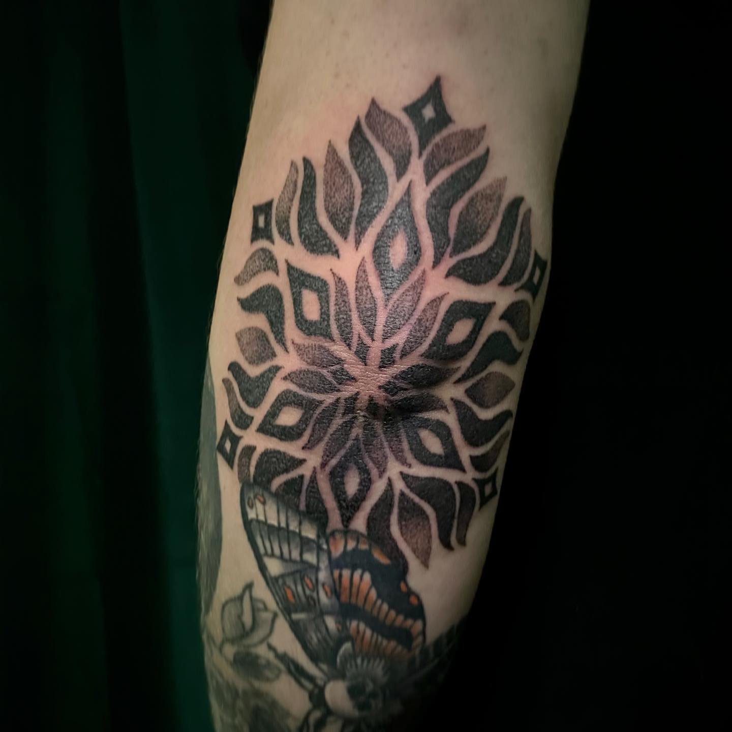 Tatuaje retro de tinta negra en el codo.