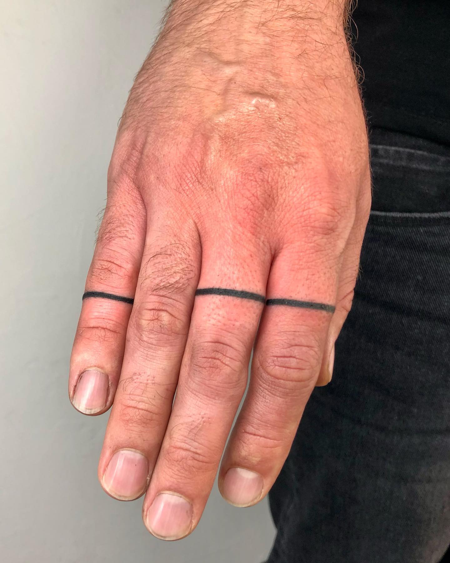 Pequeño tatuaje de líneas en el dedo.