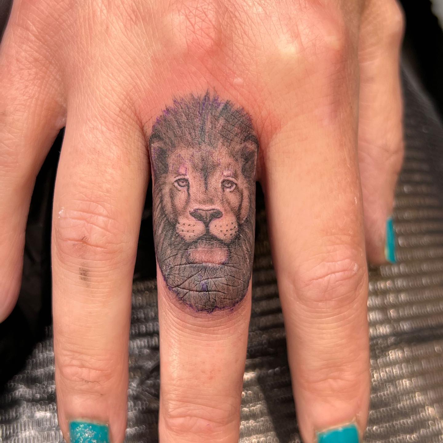 Tatuaje de león en el dedo