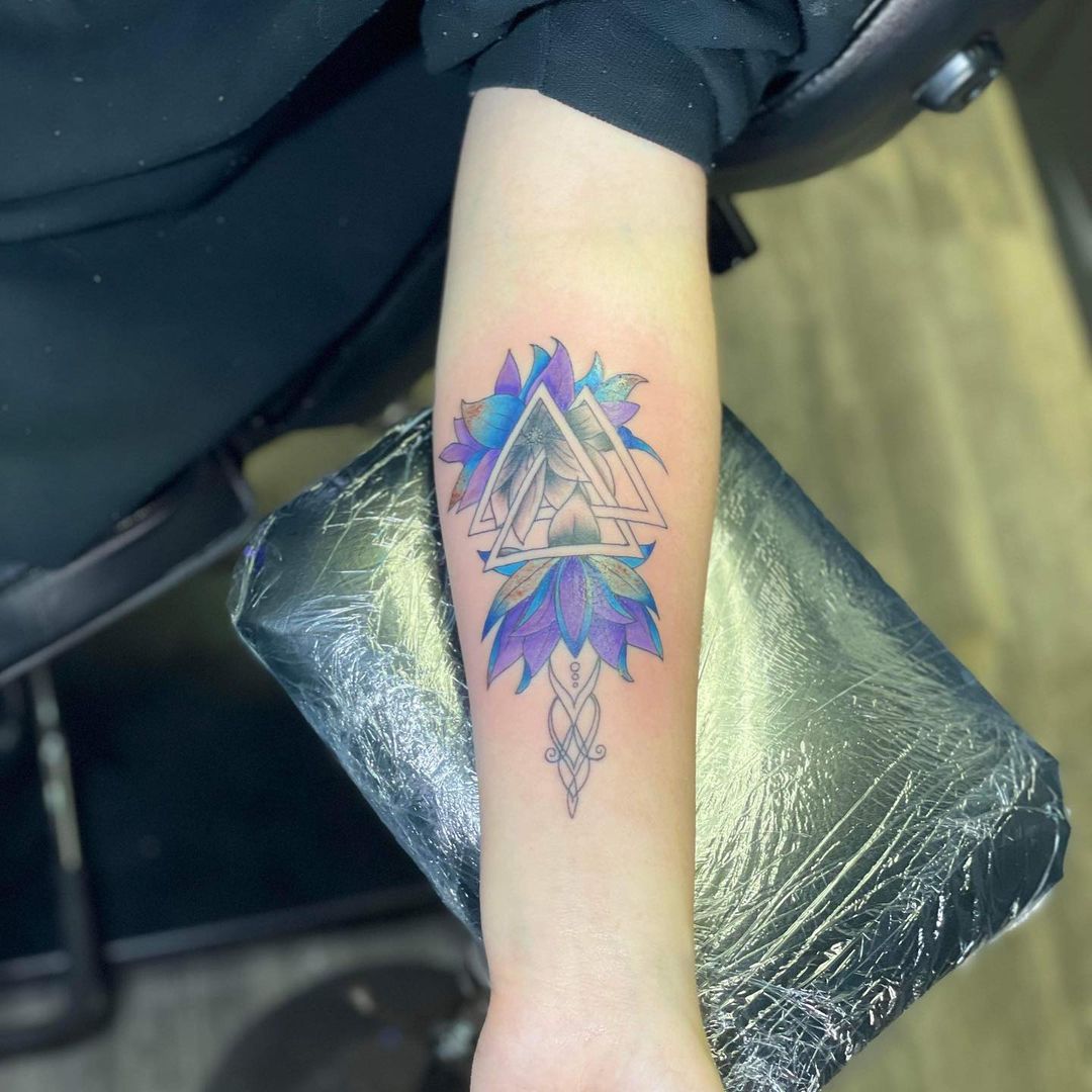 Diseño de tatuaje Valknut azul en el antebrazo.