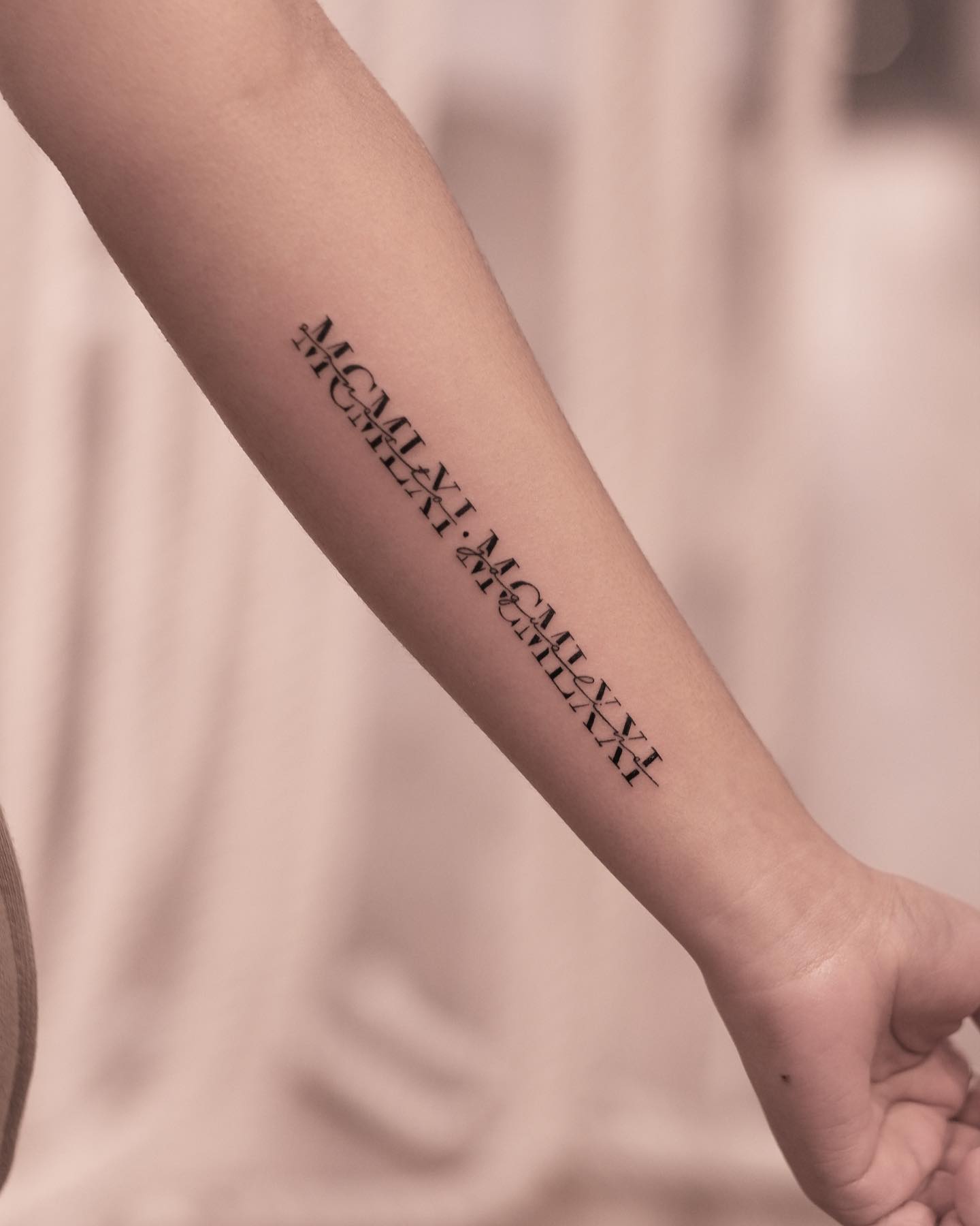 Tatuaje de brazo con números romanos.