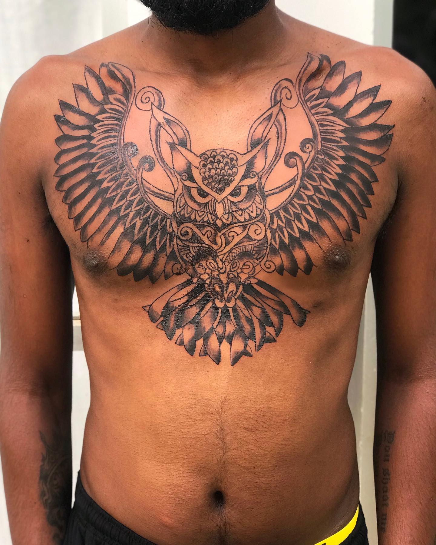 Tatuaje de búho en el pecho.